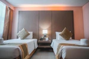 a hotel room with two beds and a lamp at Manila Grand Opera Hotel in Manila