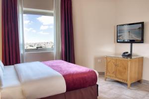 A bed or beds in a room at Geneva Hotel