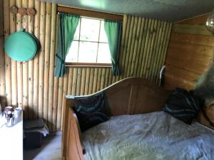 1 dormitorio con 1 cama en una habitación con paredes de madera en Treehouse op het platteland van Huize Ouwervelden, en Centrum