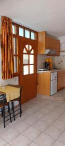 - une cuisine avec des placards en bois, une table et une porte dans l'établissement Studio NEFELI Β'οροφος, à Réthymnon