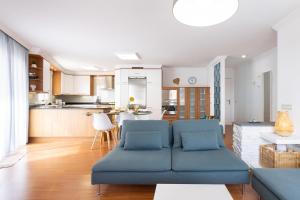 Il comprend un salon avec un canapé bleu et une cuisine. dans l'établissement Home2Book Sunny & Quiet Beach House, Pool, à Candelaria