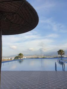 ein großer Pool mit Palmen und einem Sonnenschirm in der Unterkunft Cabo dream in Tétouan