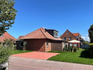 a brick house with a red roof at Marions Apartments Greetsiel in Greetsiel