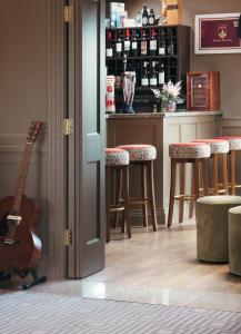 una cocina con guitarra y un bar con taburetes en Teach de Broc, en Ballybunion