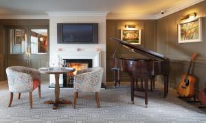 uma sala de estar com um piano e uma mesa com cadeiras em Teach de Broc em Ballybunion