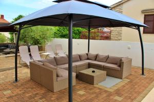 a couch under an umbrella on a patio at Apartments Kimm in Poreč