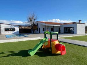 a toy slide on the grass in front of a house at El cortijo del abuelo pepe in Alhendín
