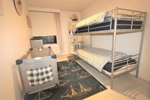 een slaapkamer met een stapelbed en een tapijt bij Villa Georges met tuin en sauna in Koksijde