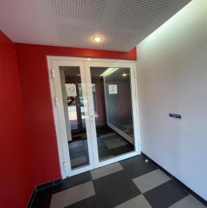 Pokój z czerwonymi ścianami i szklanymi drzwiami w obiekcie The Barbots apartment w mieście Gujan-Mestras