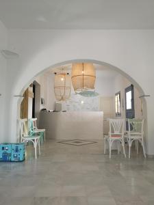 Aeolos Apartments في كاماراي: غرفة بها قوس مع كراسي ومكتب