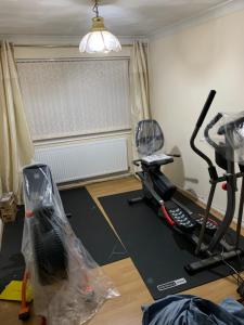a living room with a gym with a treadmill and a room with at Affordable Suites in Summerseat