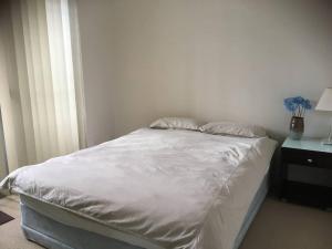 uma cama branca com duas almofadas em cima em Merivale stay in South Brisbane two beds two baths one parking em Brisbane