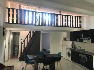 Apartamento con cocina con mesa de comedor y escalera. en Charmant 3 pièces 3 eme etage, en Sospel