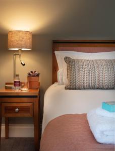 a bedroom with a bed and a lamp on a night stand at Teach de Broc in Ballybunion