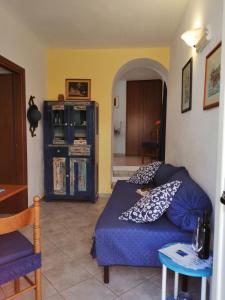 una sala de estar con un sofá azul con almohadas. en Appartamenti le conchiglie e le Stelle Marine, en Cala Gonone