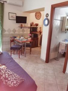 a living room with a table and a kitchen at Appartamenti le conchiglie e le Stelle Marine in Cala Gonone