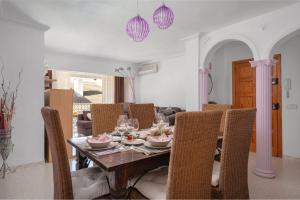 Violet House - Alcúdia في الكوذيا: غرفة طعام مع طاولة وكراسي خشبية