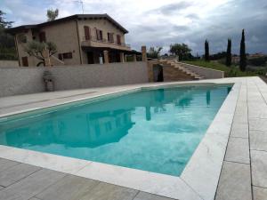 a swimming pool in front of a house at B&B L' Antica Fonte in Spinetoli