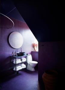 a bathroom with a toilet and a round mirror at The Norrmans Castle in Genarp