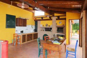 cocina con paredes amarillas, mesa y sillas en Casa Rosaria, en Vietri