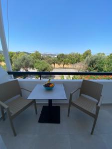 a table and two chairs on a balcony at Ikaros Studios in Faliraki