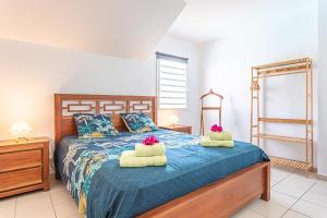 a bedroom with a bed with two pillows on it at Ô Rêves Bleus in Saint-François