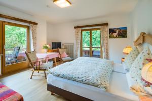 een slaapkamer met een bed en een tafel en stoelen bij Hotel-Pension-Ostler in Bad Wiessee