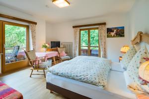 Schlafzimmer mit einem Bett, einem Tisch und Stühlen in der Unterkunft Hotel-Pension-Ostler in Bad Wiessee
