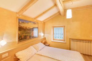 una camera da letto con un letto e un dipinto sul muro di Appartamento Giada a Livigno