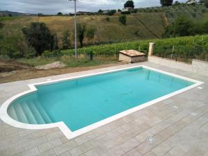een groot zwembad in een patio met bij B&B L' Antica Fonte in Spinetoli