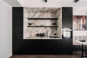 a kitchen with black and white marble walls at HIGHSTAY - Luxury Serviced Apartments - North Marais 1 in Paris