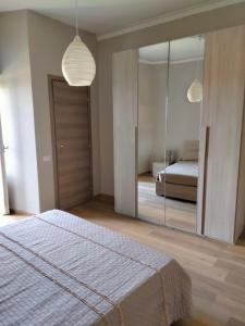 een slaapkamer met een bed en een grote spiegel bij HOME ORTE in Orte