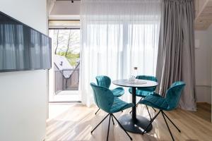 a dining room with a table and green chairs at VineWood Apartment, By Cohost in Palanga