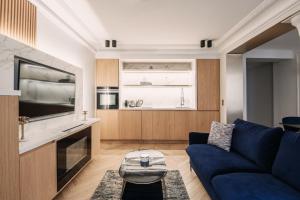巴黎HIGHSTAY - Luxury Serviced Apartments - Louvre-Rivoli Area的一间带蓝色沙发的客厅和一间厨房