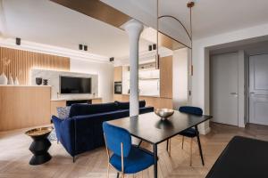 a living room with a table and blue chairs at HIGHSTAY - Luxury Serviced Apartments - Louvre-Rivoli Area in Paris