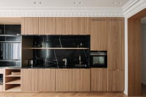 a kitchen with wood paneling and black appliances at HIGHSTAY - Luxury Serviced Apartments - Champs-Elysées in Paris