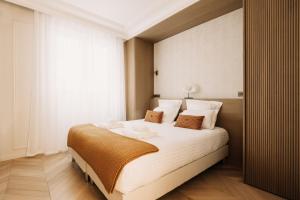 a bedroom with a large bed with white sheets at HIGHSTAY - Luxury Serviced Apartments - Champs-Elysées in Paris