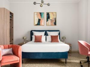 米兰Numa Milan Loreto的一间卧室配有蓝色的床和椅子