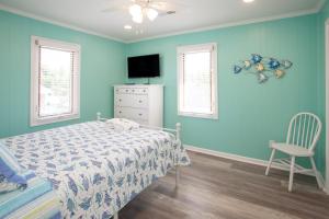 a bedroom with blue walls and a bed and a chair at Lazy Day-Z in Virginia Beach