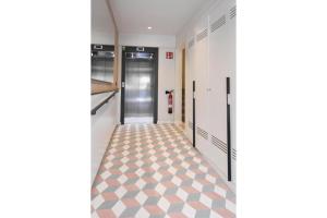 un pasillo con un pasillo con puertas y suelo de baldosa en APG Girona Carme 19, en Girona