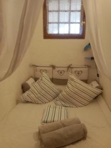 una camera da letto con letto, cuscini e finestra di VUE SUR MER VISTA HERMOSA ARGELES SUR MER PLAGE ad Argelès-sur-Mer