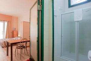 Habitación con mesa y puerta de cristal en Loft Marini, en Villa San Pietro