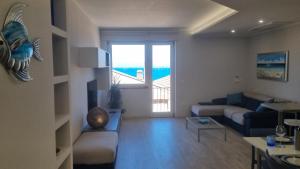 a living room with a couch and a large window at Appartamento del Sole in Porto Santo Stefano +34 photos