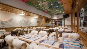 a dining room with white chairs and tables and a ceiling at Lodge Bergrestaurant Kleine Scheidegg in Kleine Scheidegg