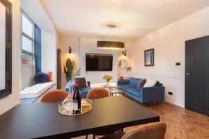 - un salon avec un canapé bleu et une table dans l'établissement Capri Stays - Apartment One, à Blackpool
