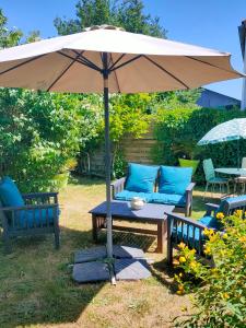 a picnic table with an umbrella in a yard at Chambres Peyroutas "Amélie" à Vignonet St Emilion in Vignonet