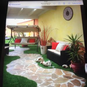 a living room with a couch and some plants at Appartamento Villa Serena due in Maracalagonis