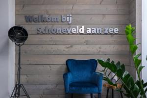 ein blauer Stuhl an einer Holzwand mit den Worten, die von gelehrt wurden in der Unterkunft EuroParcs Schoneveld in Breskens