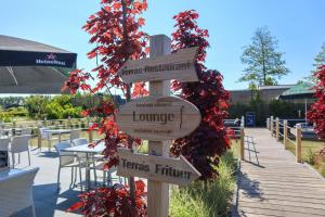 um sinal de madeira com sinais para diferentes destinos em EuroParcs Schoneveld em Breskens