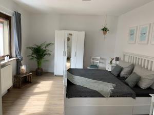 een slaapkamer met een bed in een witte kamer bij Auszeit im Ahrtal in Bad Neuenahr-Ahrweiler